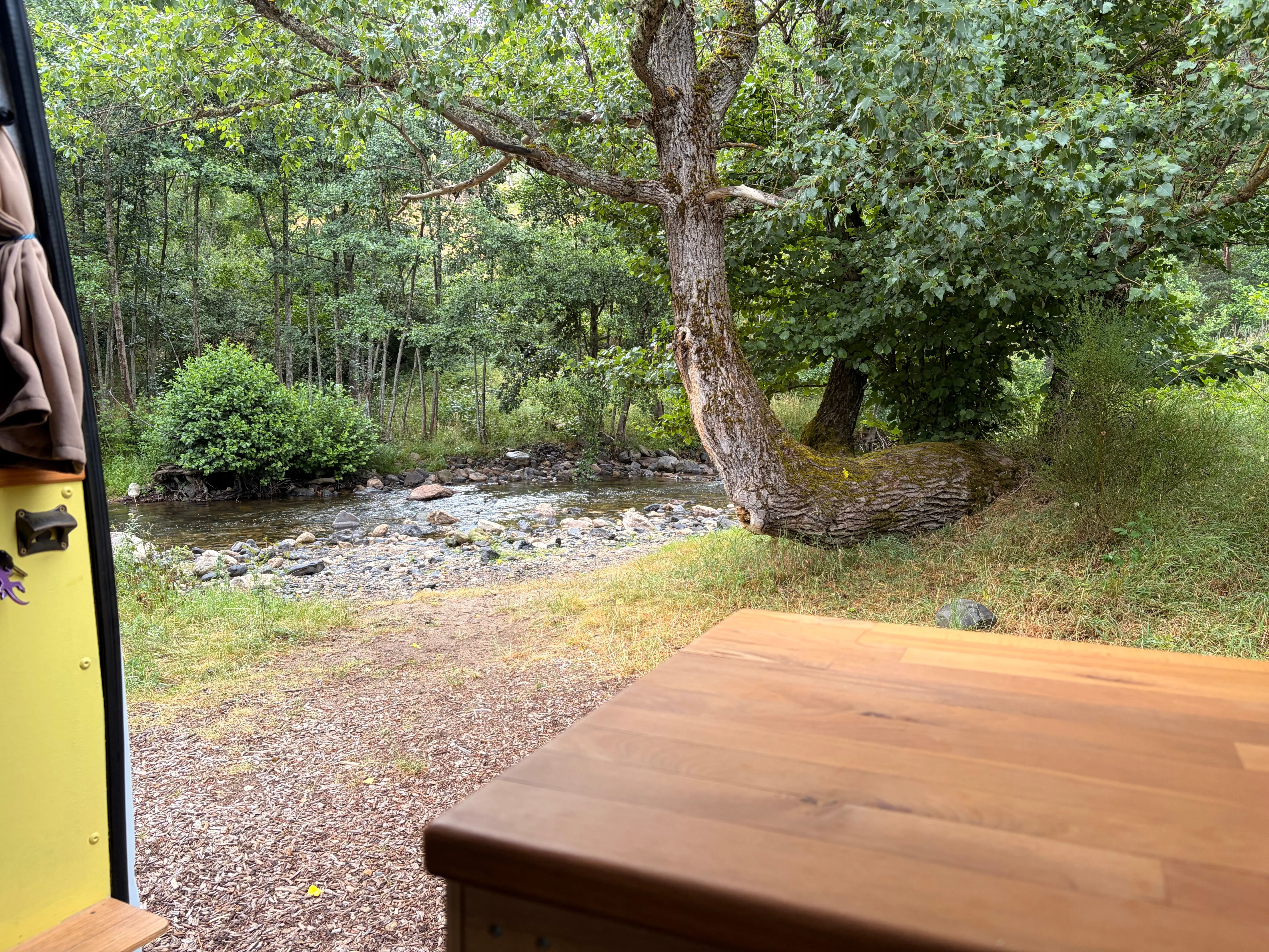 Van garé à l'ombre au bord d'une rivière, le bon réflexe anti-chaleur